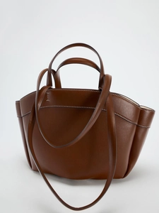 Brown leather tote bag with white contrast stitching and adjustable shoulder strap