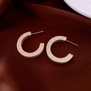 Detailed view of 14k gold plated C-hoop earrings featuring pave-set sparkling crystals
