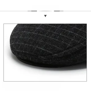 Detailed close-up of a sturdy flat cap visor with grey plaid wool and reinforced stitching