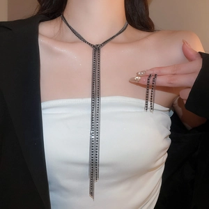 Dettaglio della collana con nappine a strati e orecchini di diamanti abbinati su una modella