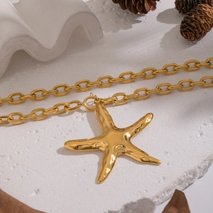 Detailed view of a gold starfish pendant on a chunky chain with beach style accessories
