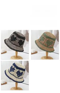 Détail de chapeaux de paille tissés avec motifs de cœurs ajourés en trois coloris divers