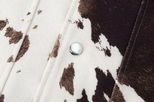 Dettaglio giacca animalier in ecopelliccia con bottone a pressione in metallo argento