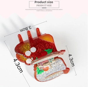Detail of red glitter Christmas hat hair claw with green leaf and white berry pattern