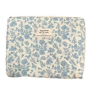 Quilted makeup bag with blue floral print and metal zipper in a high-capacity design