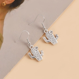 Détail de boucles d'oreilles cactus argentées avec crochets et texture métallique élégante