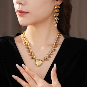 Gros plan d'un mannequin portant un collier et des boucles d'oreilles épi de blé doré