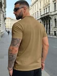 Rear view of khaki short-sleeve cotton T-shirt on male model in urban street setting