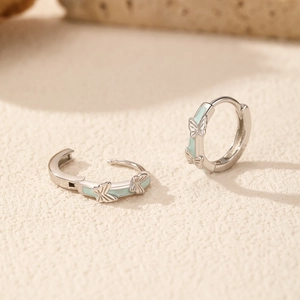 Elegant s925 silver butterfly earrings with light blue enamel on a textured surface