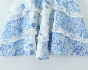 Detailed close-up of blue floral print and delicate lace hem on a V-neck dress