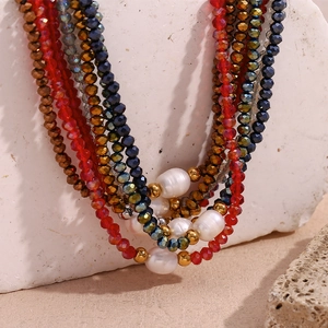 Detailed macro view of colorful beaded necklace with pearls on a textured white stone