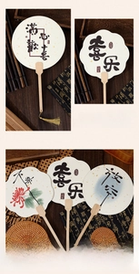 Detailed view of Chinese silk fans with golden tassels and artistic calligraphy on wood