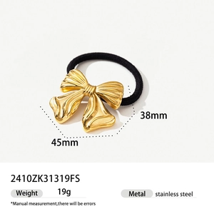 Detail of a 45mm golden stainless steel bow hair tie with textured finish and black band