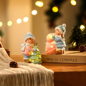 Light-up ceramic Christmas boy and girl ornaments with festive warm glowing light