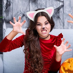 Bambina con cerchietto orecchie di gatto in peluche bianco e rosa per costume di Halloween