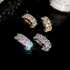 Detailed close-up of four sparkling rhinestone-encrusted hair clips with metallic finish