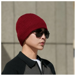Detailed view of dark red ribbed knit texture on a thick winter beanie for men