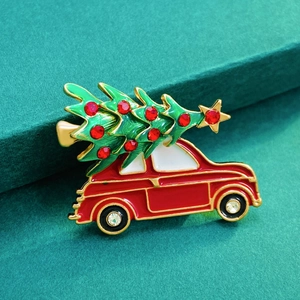 Detailed view of Christmas car brooch with red rhinestones on dark green stand