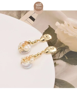 Detail of baroque pearl drop earrings with 18k gold plating and crystal cluster accents