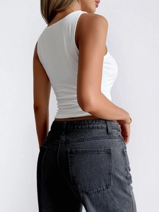 Side view of a white sleeveless Y2K crop top paired with dark grey jeans on a model