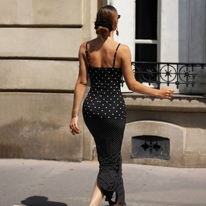 Elegante Rückansicht eines figurbetonten schwarzen Polka-Dot-Midikleids mit Spaghettiträgern