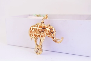Detailed close-up of golden elephant pendant with hollow heart design and smooth finish