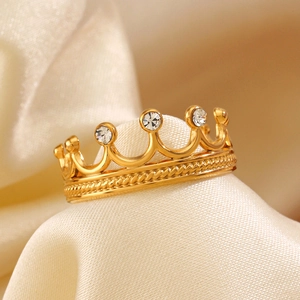 Bague couronne dorée en acier inoxydable avec zircons blancs sur fond en soie beige