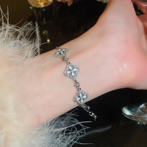 Detail eines vierblättrigen Kleeblatt-Armbands mit weißem Perlmutt und Zirkonia-Steinen