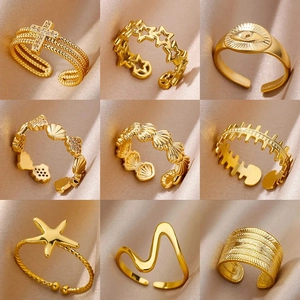 Detailed grid of assorted 18K gold stainless steel charms rings on silk fabric