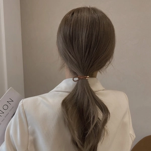 Brown braided high-elasticity hair tie with gold metal knot on a low ponytail