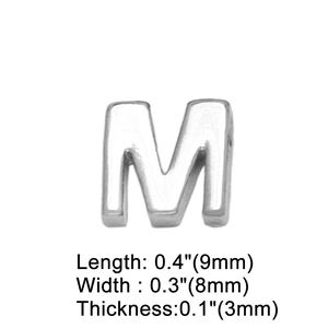Dettaglio macro del ciondolo lettera M argento con dimensioni di 9mm x 8mm e 3mm di spessore