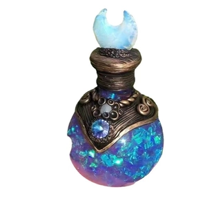 Magic potion bottle ornament with blue iridescent flakes and a glowing crescent moon stopper