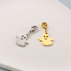 Ghost pendant charms with lobster clasps in gold and silver finishes on white surface