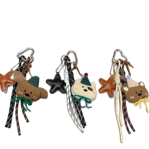 Tre portachiavi a forma di orsetto di peluche con corde intrecciate e ciondoli a stella