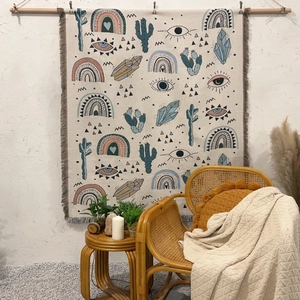 Detail of bohemian woven blanket with rainbow patterns and fringe on a wooden rod