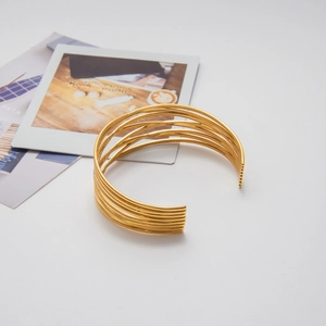 Dettaglio del bracciale aperto multistrato placcato oro 18K con design minimalista