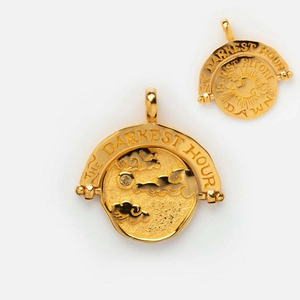 Detailed view of rotating gold pendant engraved with The Darkest Hour inspirational text