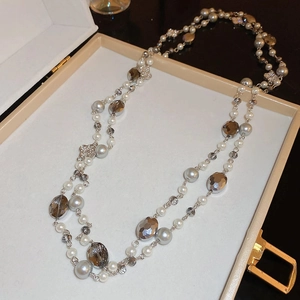 Close-up of floral clover pendant necklace with grey pearls and faceted beads