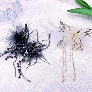 Elegant butterfly hair claw with feathers and long tassels on white textured background