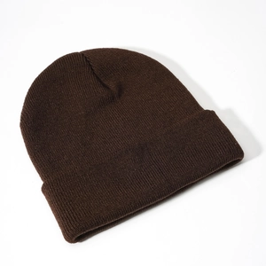 Detail view of dark brown knitted beanie with ribbed texture and cuffed design