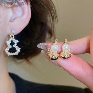 Macro view of gold gourd earrings with inlaid diamonds and pearls in Neo-Chinese style