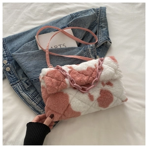Detailed view of pink and white plush crossbody bag with chain and diamond quilted pattern