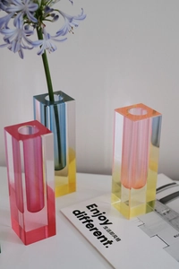 Detail of modern gradient acrylic vases in pink and blue for minimalist floral arrangements