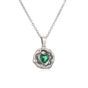 Macro shot of silver necklace featuring an irregular frame and a green heart zircon pendant