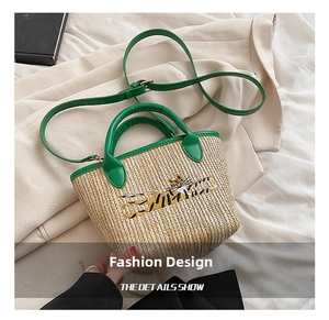 Detail shot of a woven straw bucket bag featuring green leather trim and tiger embroidery