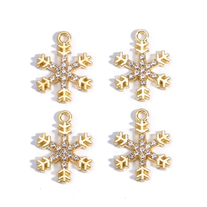 Close-up of four gold snowflake pendants with inlaid rhinestones for DIY jewelry making