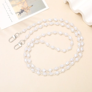 Detail of handmade crossbody phone strap with white pearls and faceted clear beads