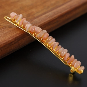 Detailed macro view of handmade wire-wrapped orange natural crystal stone hair clip