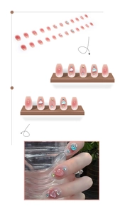 Detail of 3D heart charms and rhinestone accents on pink gradient press-on nails