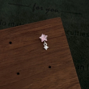 Close-up of pink star zircon earring with drop diamond on vintage wood stand
